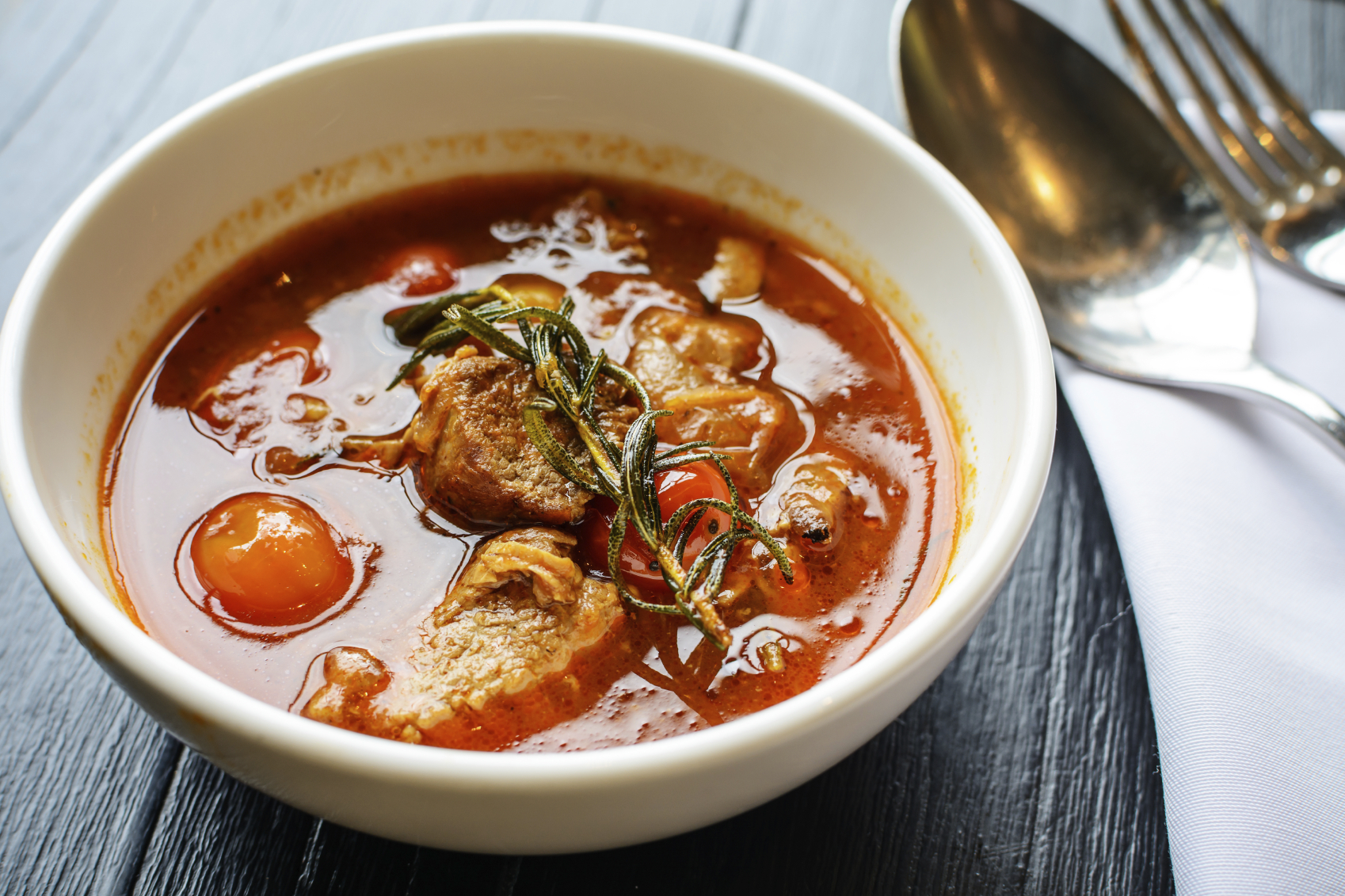Close up of Pork stew in white bowl on wooden table