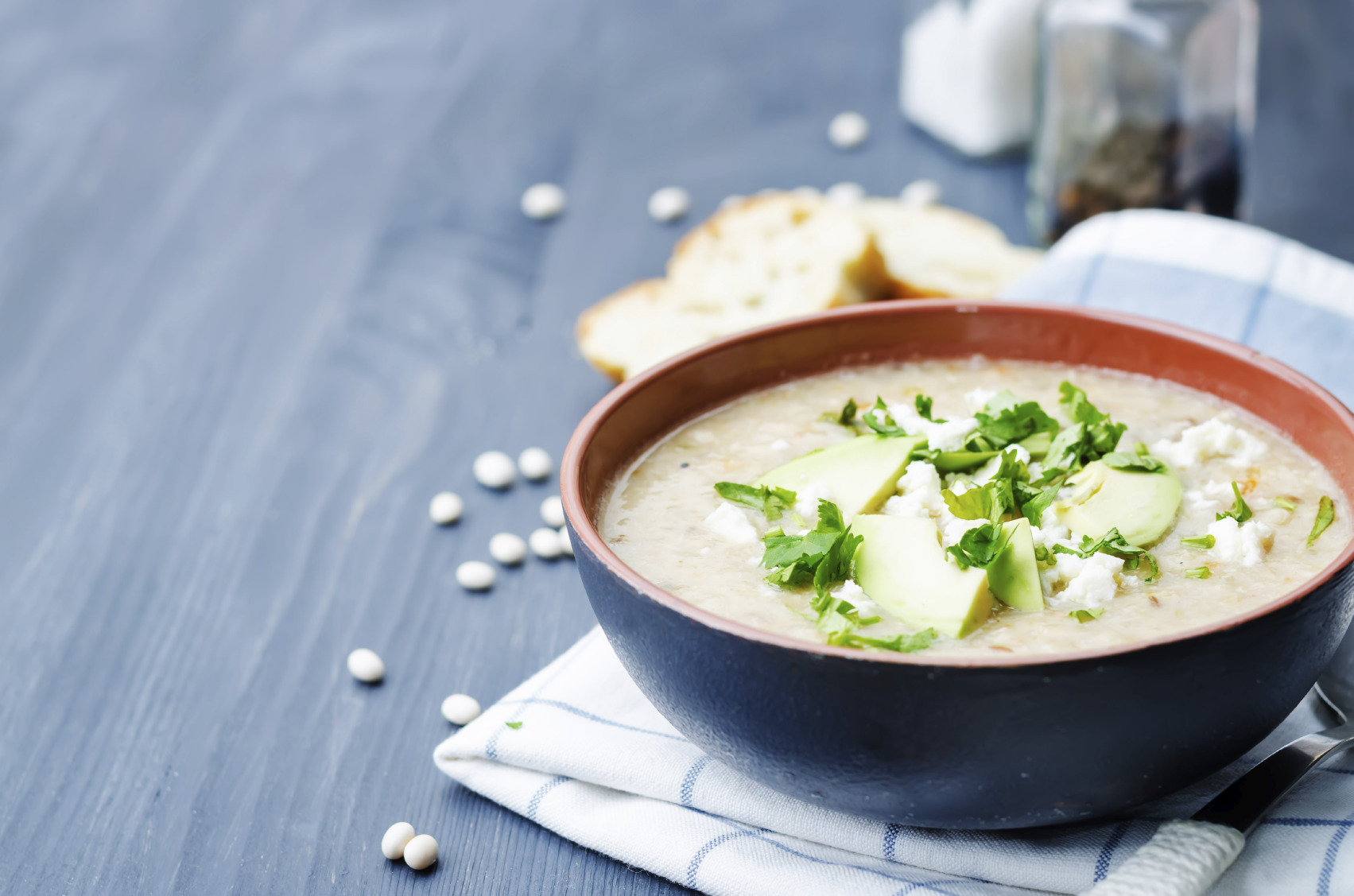 White beans chicken soup on a dark wood background. toning. selective focus