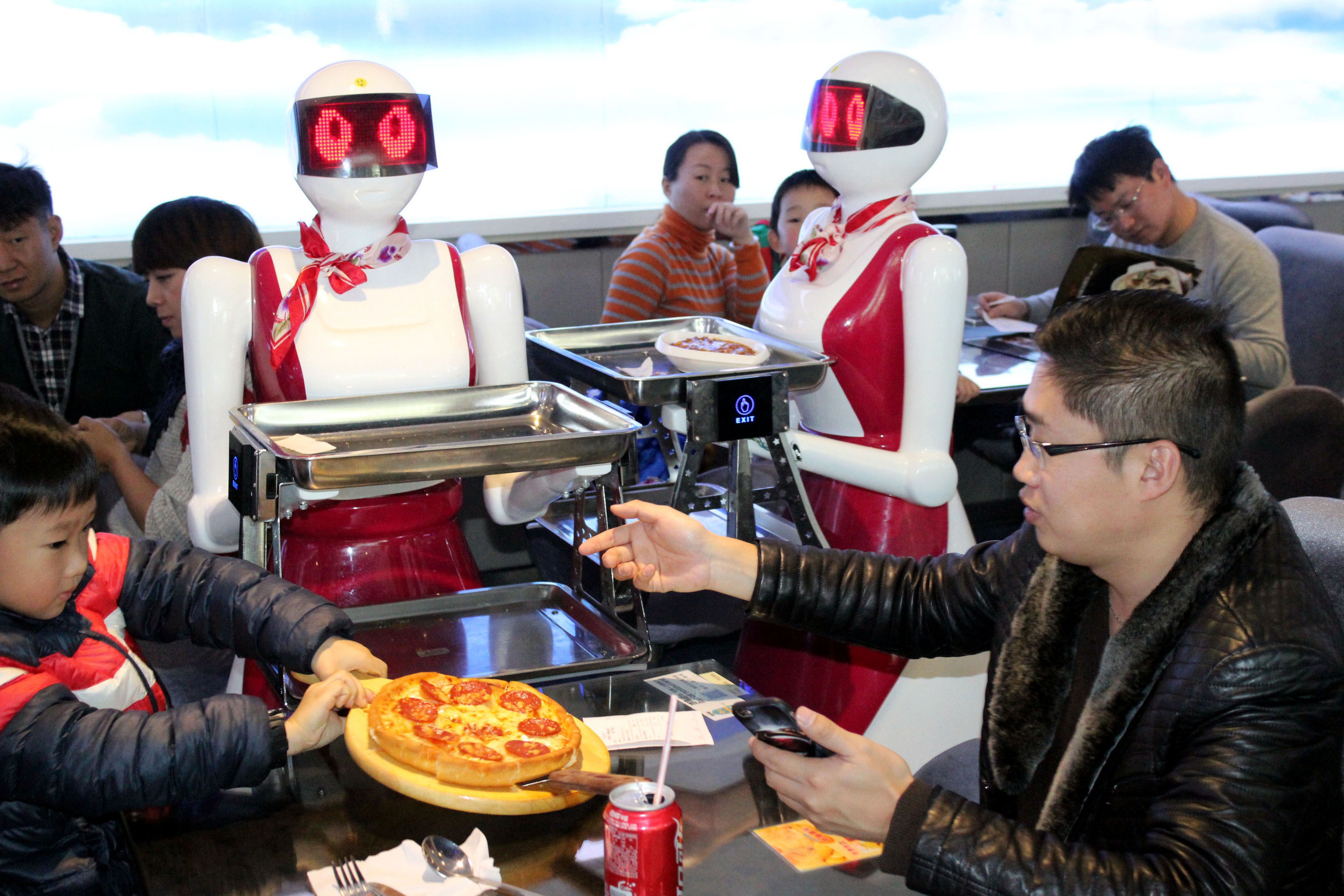 SUZHOU, CHINA - DECEMBER 10:  (CHINA OUT) Robots deliver meals for customers at a restaurant on December 10, 2015 in Suzhou, China. The restaurant has four robots delivering meals, one robot welcoming and over ten robots performing.  (Photo by ChinaFotoPress/ChinaFotoPress via Getty Images)