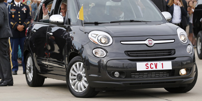 Pope Francis waves as he is driven away in a Fiat 500 model after arriving in the United States at Joint Base Andrews outside Washington September 22, 2015.    REUTERS/Jonathan Ernst  - RTX1RY4T