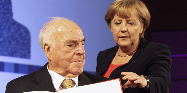 Germany's former Chancellor Helmut Kohl and German Chancellor Angela Merkel attend a stamp unveiling ceremony during a reception in Berlin, September 27, 2012.  REUTERS/Wolfgang Kumm/Pool (GERMANY - Tags: POLITICS) - RTR38IB4