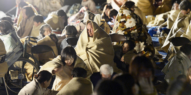 Local residents wrap themselves in blankets as they sit on the road in front of the town office building after an earthquake in Mashiki town, Kumamoto prefecture, southern Japan, in this photo taken by Kyodo April 15, 2016. Mandatory credit REUTERS/Kyodo  ATTENTION EDITORS - FOR EDITORIAL USE ONLY. NOT FOR SALE FOR MARKETING OR ADVERTISING CAMPAIGNS. THIS IMAGE HAS BEEN SUPPLIED BY A THIRD PARTY. IT IS DISTRIBUTED, EXACTLY AS RECEIVED BY REUTERS, AS A SERVICE TO CLIENTS. MANDATORY CREDIT. JAPAN OUT. NO COMMERCIAL OR EDITORIAL SALES IN JAPAN. 