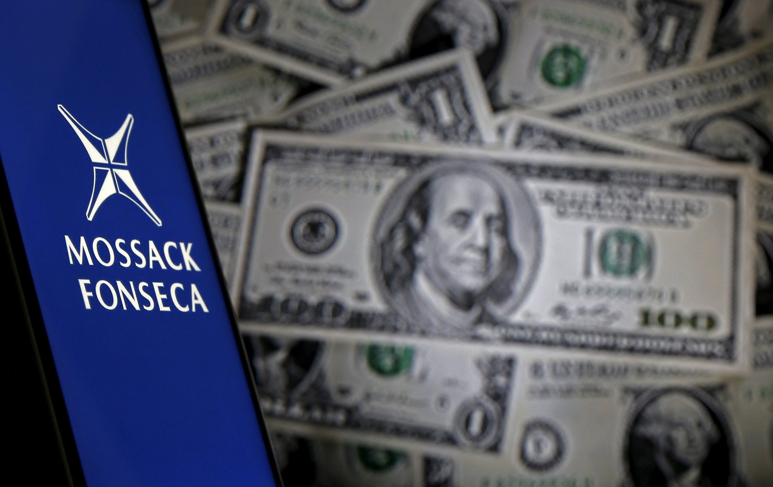 Smartphone with Mossack Fonesca logo is seen in front of a display of U.S. banknotes in this illustration taken April 11, 2016. REUTERS/Dado Ruvic/Illustration/File Photo