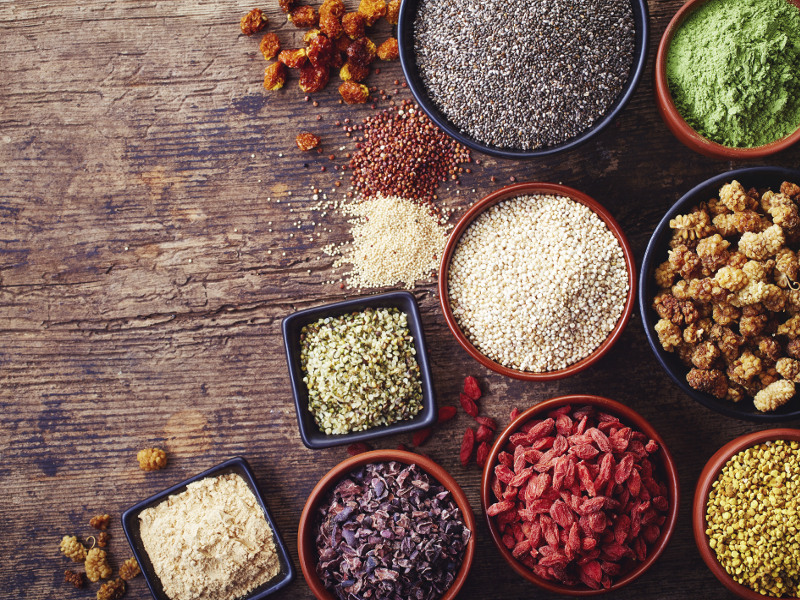 Bowls of various superfoods on wooden  background