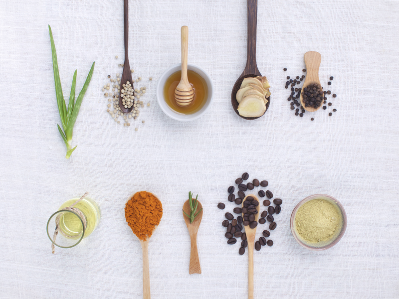 herb variety on rustic white background from top view, oil, coffee, beans, pepper, aloe vera, turmeric, ginger, rosemary