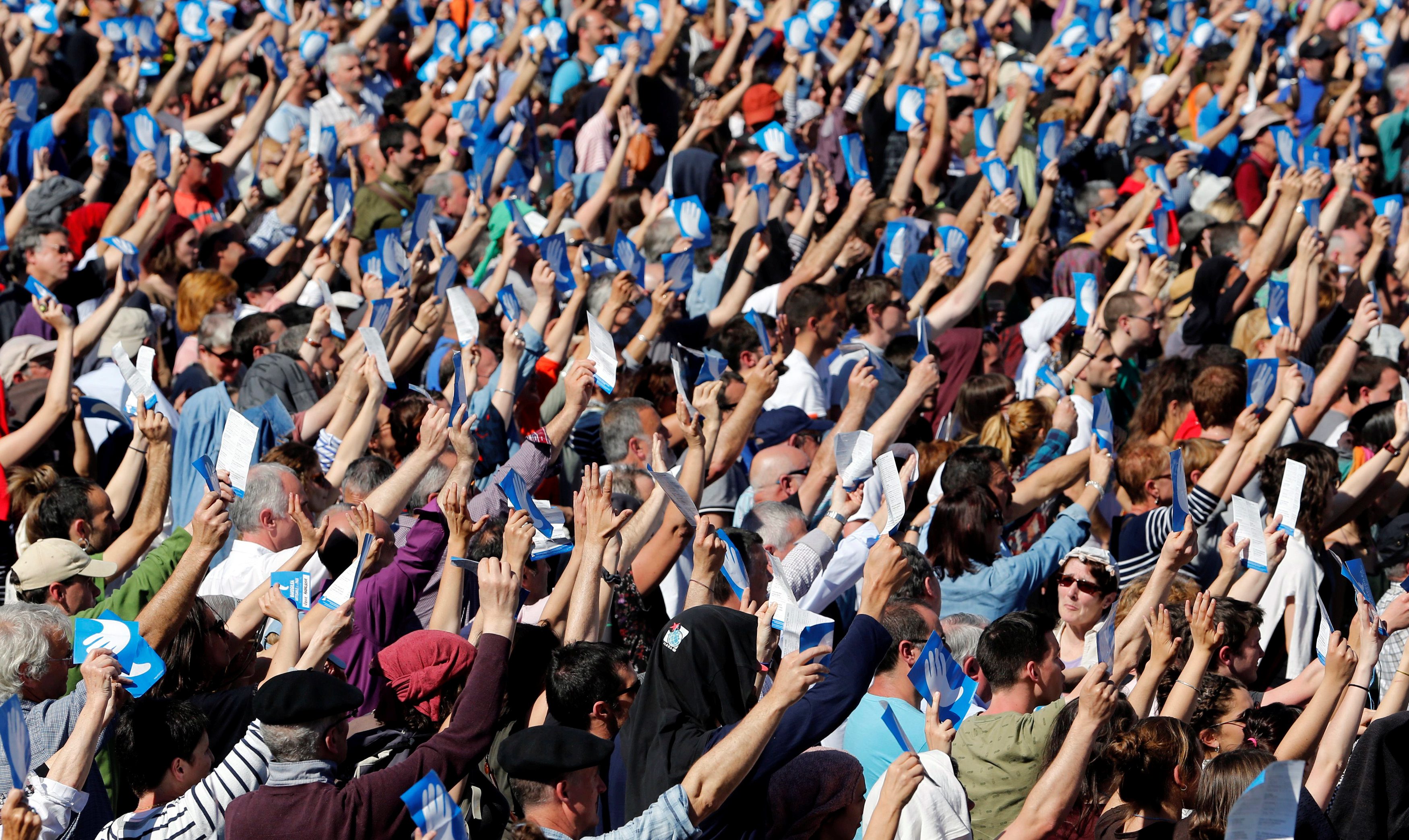 Ljudi podižu simbol mira na skupu nakon razoružanja ETA-e
