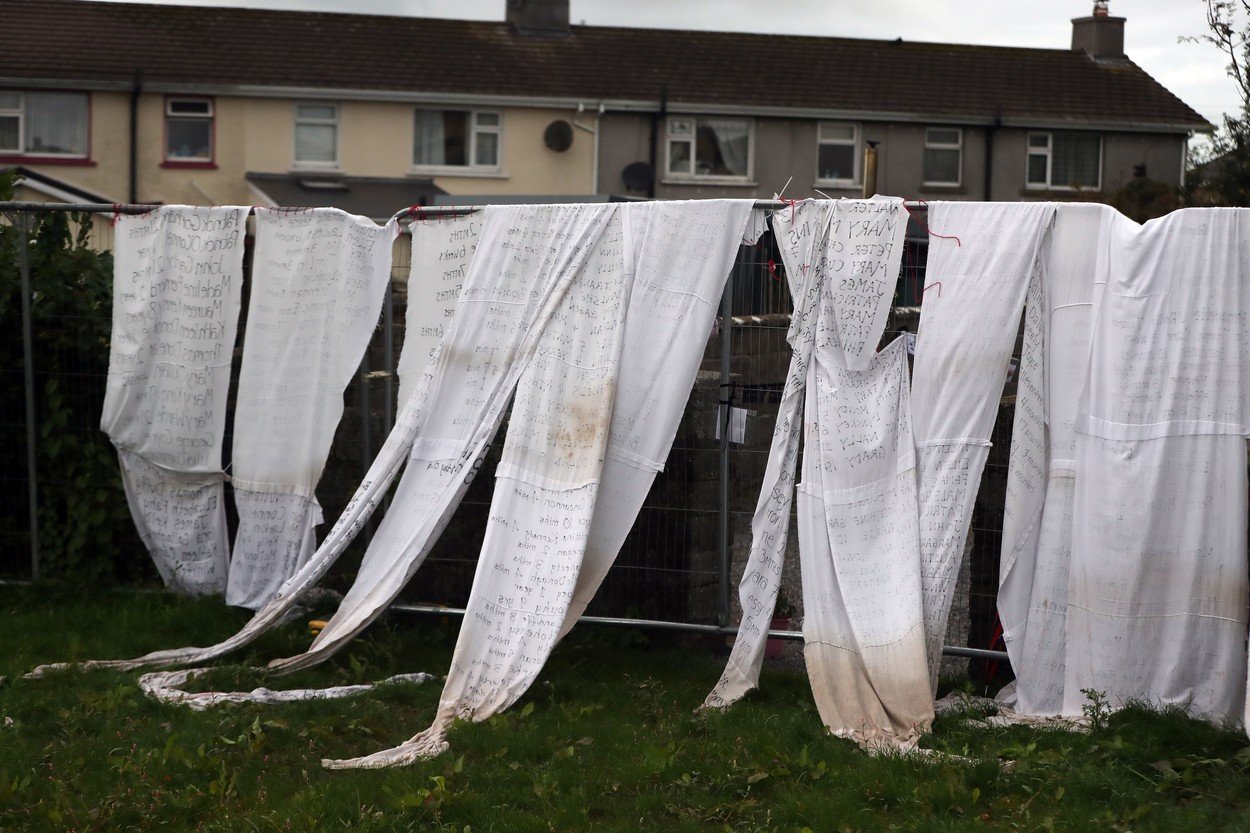 Plahte s imenima umrle djece vezane su uz ogradu bivšeg doma za neudane majke u Tuamu, gdje je otkrivena masovna grobnica