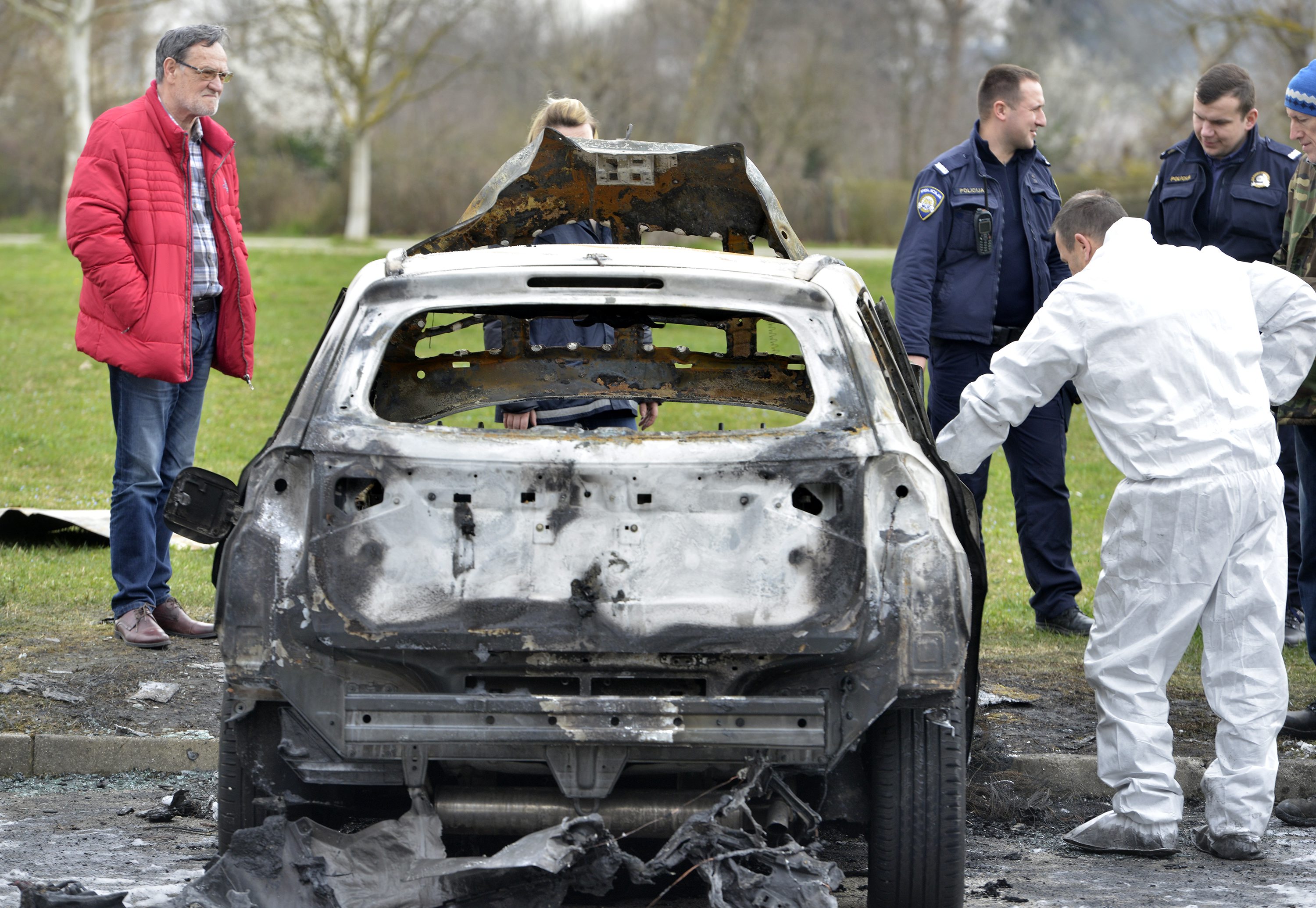 Policijski očevid na mjestu paleža i vlasnik Mirko Đinkić (u crvenoj jakni) kraj izgorjelog automobila