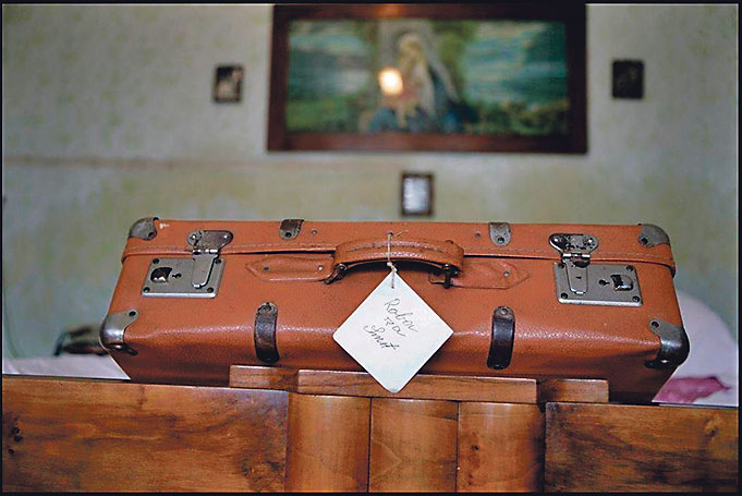 Kofer s ceduljom na kojoj piše “Roba za Smrt” glavni je motiv na fotografijama nastalim 2011. godine