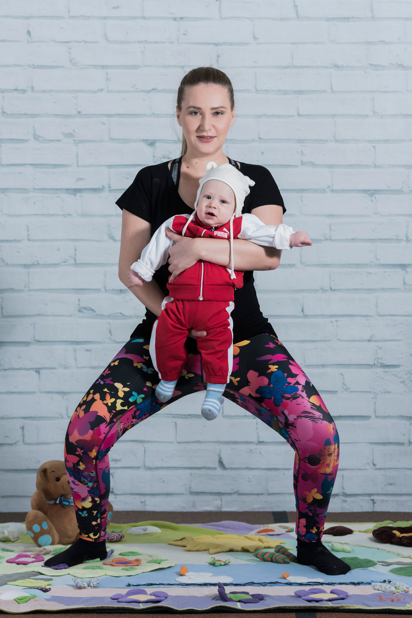 ŠIROKI ČUČANJ
Vježba za unutarnju stranu bedra i stražnjicu.
Stanite u raskoračni stav šire od širine kukova. Stopala raširite prema van i težinu održavajte na petama. Bebu držite u rukama kako se ona inače voli nositi. Udahom se spuštajte u čučanj, na izdah se polagano podižite gore dodatno stišćući stražnjicu za bolji rezultat.
Vježbu ponovite 10-12 puta.