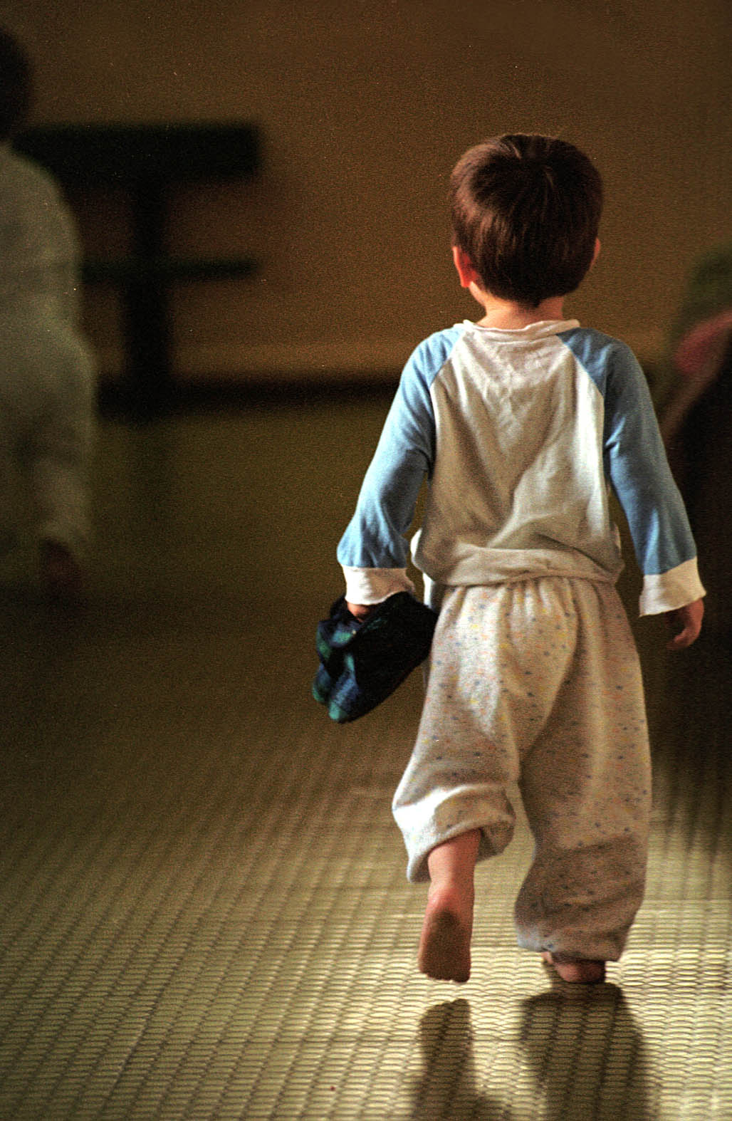 OVAJ DJEČAK JE SRETNO POSVOJEN
Fotografiju bosonogog dječaka u pidžami koji tapka po pločicama i nosi papučice u rukama snimio je prije 18 godina na hodniku zagrebačkog doma za djecu bez odgovarajuće roditeljske skrbi fotograf Dražen Kokorić, a Jutarnji ju je list objavio nebrojeno puta. Dječak s fotografije posvojen je vrlo brzo nakon što je fotografija nastala i s roditeljima se odselio u jednu zapadnoeuropsku zemlju, u kojoj živi