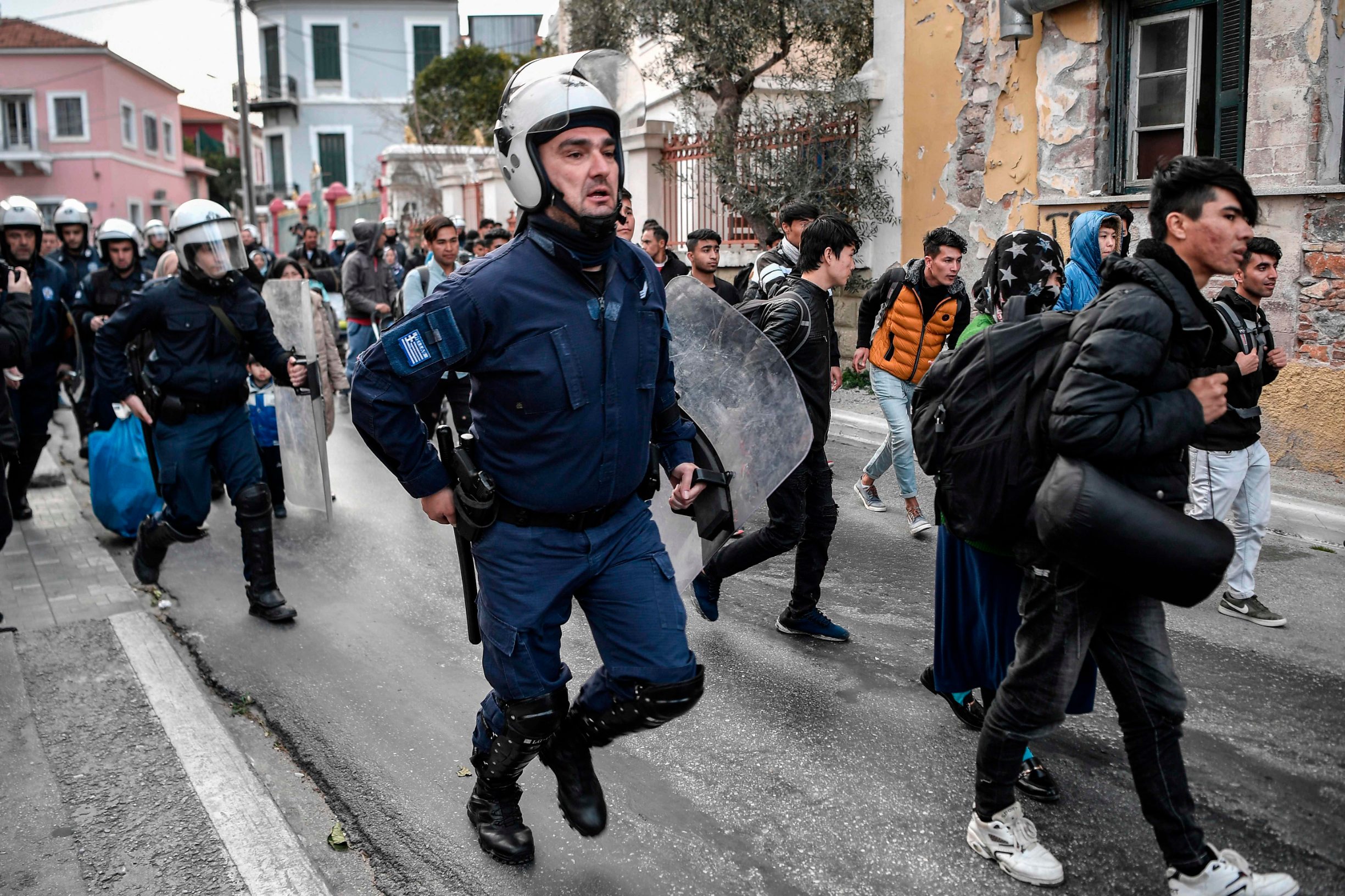 Greek anti-riot police run after migrants and refugees