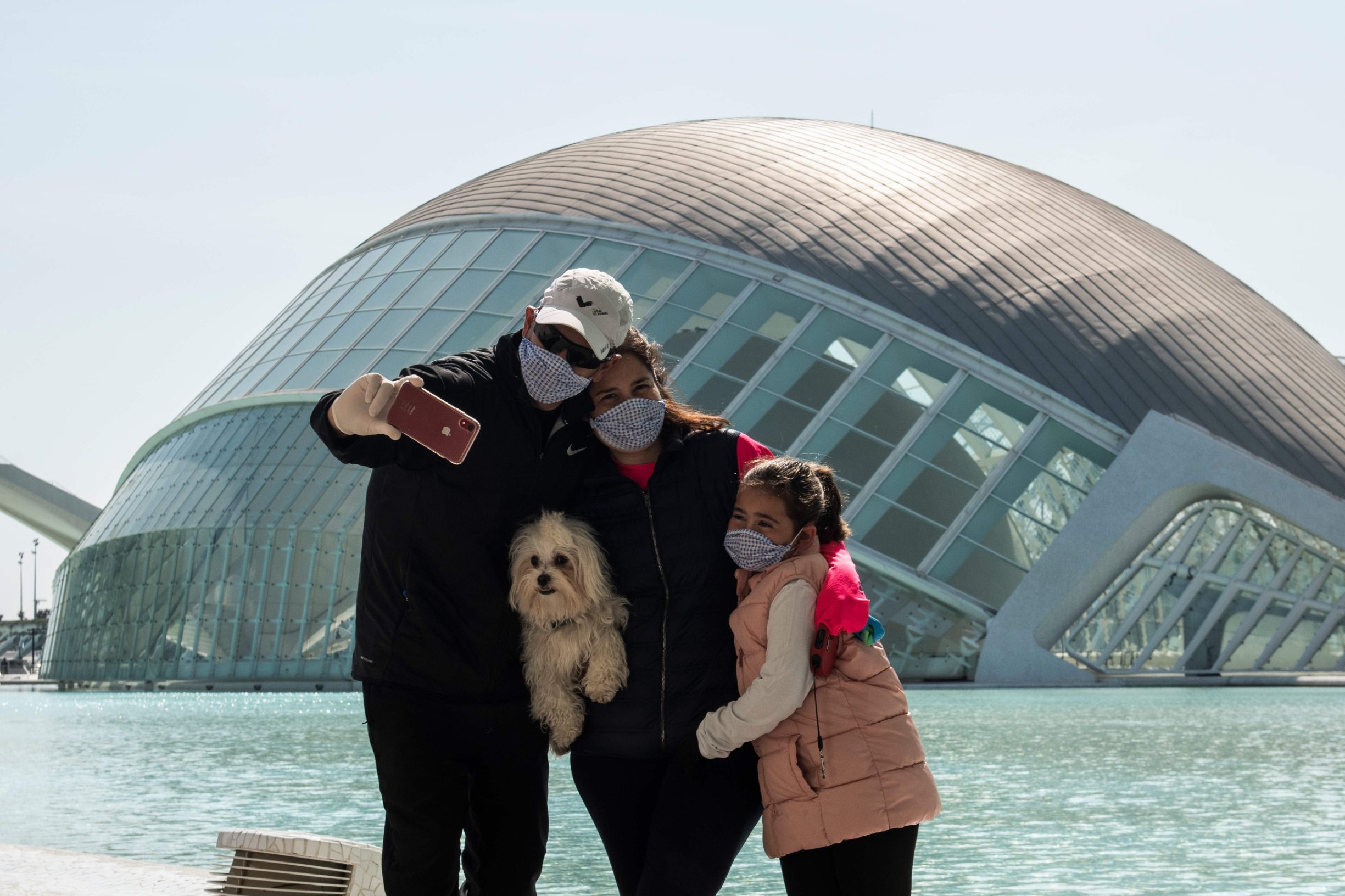 A family wearing protective masks take a selfie at the City of Arts and Sciences in Valencia on March 14, 2020 as Spain confirmed more than 1,500 new cases of coronavirus between Friday and Saturday raising its total to 5,753 cases, the second-highest number in Europe after Italy.