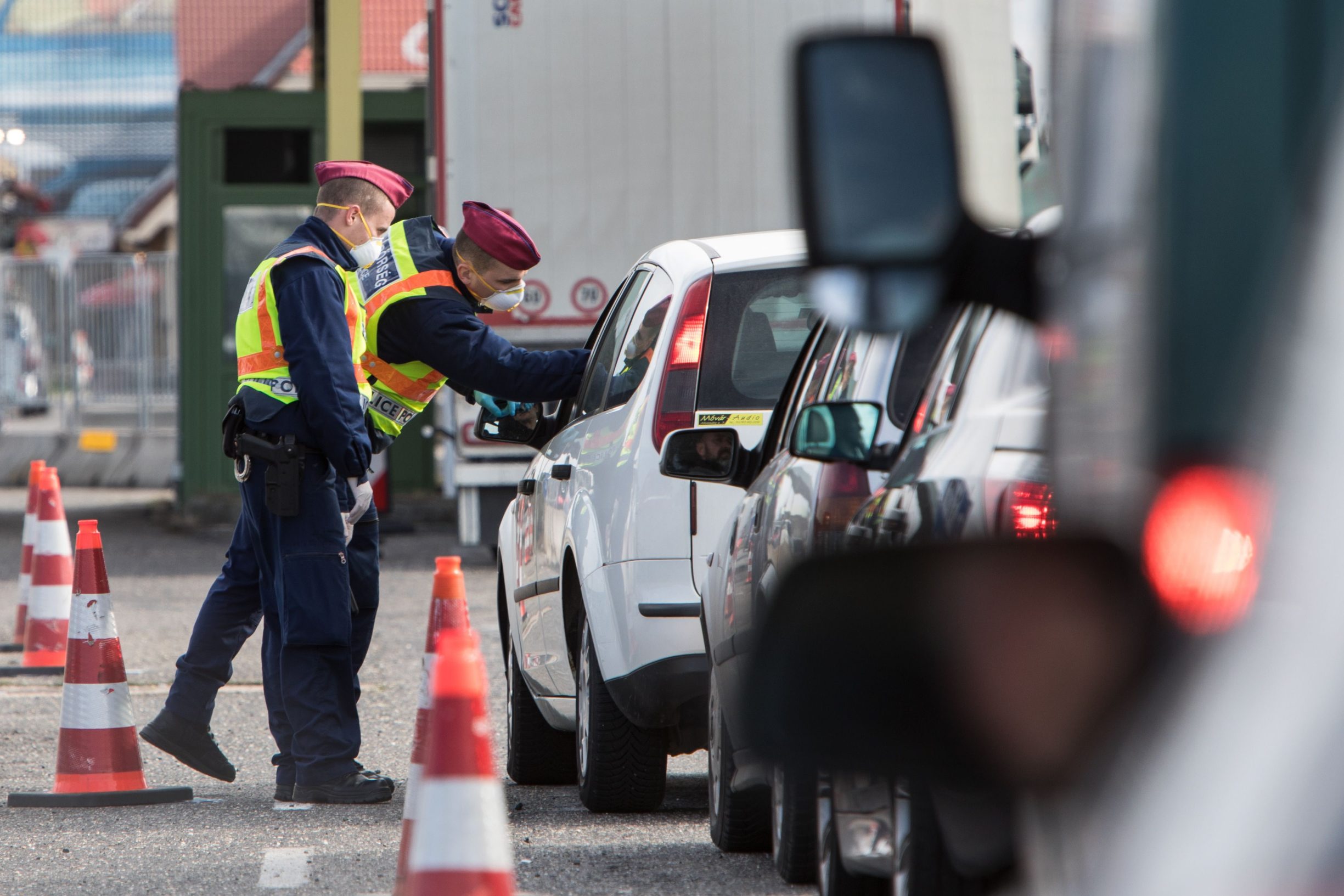 Mađarski policajac mjeri temperaturu putniku na granici Austrije i Mađarske