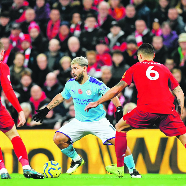 Manchester City's Argentinian striker Sergio Aguero (C) vies with Liverpool's English midfielder Jordan Henderson (L) and Liverpool's Croatian defender Dejan Lovren (R) during the English Premier League football match between Liverpool and Manchester City at Anfield in Liverpool, north west England on November 10, 2019. (Photo by Paul ELLIS/AFP)/RESTRICTED TO EDITORIAL USE. No use with unauthorized audio, video, data, fixture lists, club/league logos or 'live' services. Online in-match use limited to 120 images. An additional 40 images may be used in extra time. No video emulation. Social media in-match use limited to 120 images. An additional 40 images may be used in extra time. No use in betting publications, games or single club/league/player publications. /