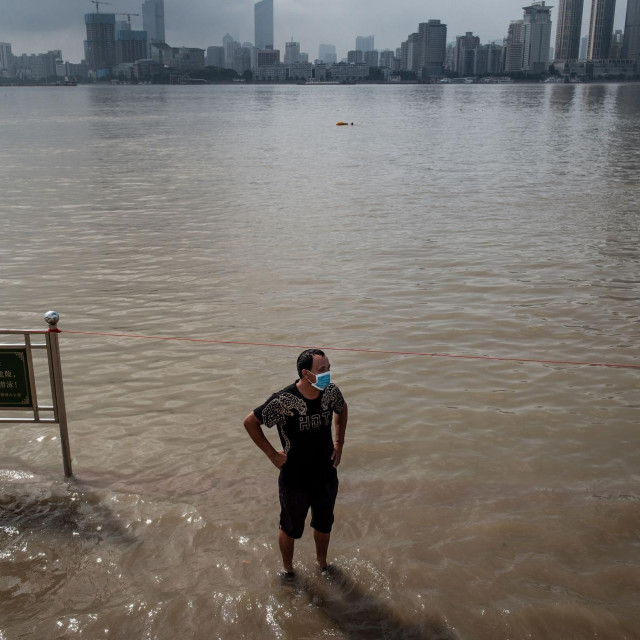 Muškarac na poplavljenim ulicama pored rijeke Yangtze