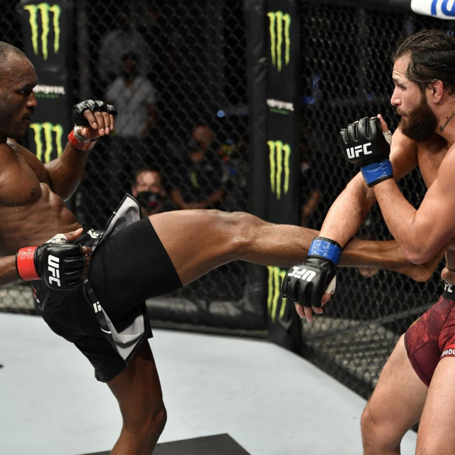 A handout image released by the Ultimate Fighting Championship (UFC) on July 12, 2020, shows Nigeria's Kamaru Usman (L) kicking US' Jorge Masvidal in their welterweight championship fight during the UFC 251 event at UFC Fight Island in Abu Dhabi's Yas Island. (Photo by Jeff BOTTARI/ZUFFA LLC/AFP)/=== RESTRICTED TO EDITORIAL USE - MANDATORY CREDIT ”AFP PHOTO/HO/ZUFFA LLC” - NO MARKETING NO ADVERTISING CAMPAIGNS - DISTRIBUTED AS A SERVICE TO CLIENTS ===