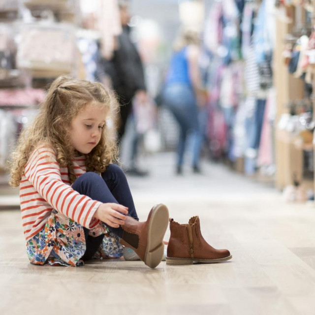 Little girl trying on shoes in a store. Shoe shopping, shoes, children, store