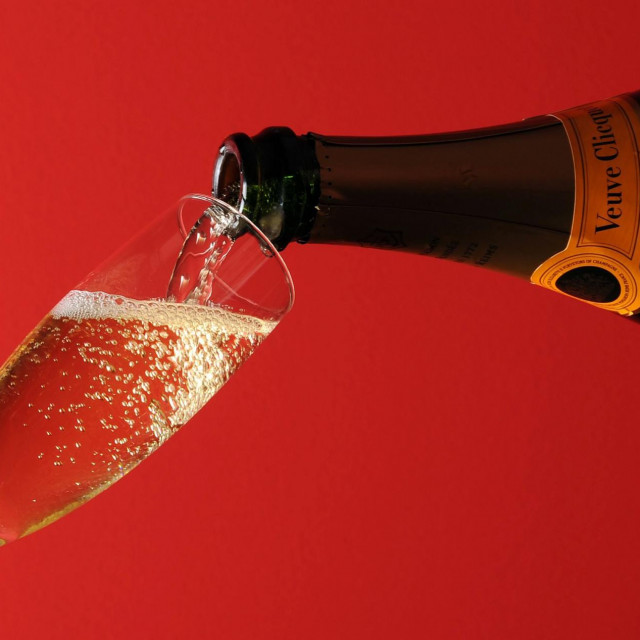 (FILES) In this file photo taken on December 29, 2010, in Paris, a glass is being filled up with champagne. - The consumption of champagne highly affected by the health crisis, but Champagne winegrowers still hope to save the year if the second wave of the epidemic does not prohibit gatherins for the end of the year celebrations. (Photo by Miguel MEDINA/AFP)