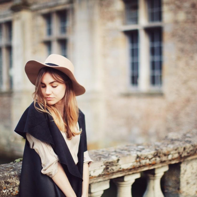 Young woman standing in front of a castle