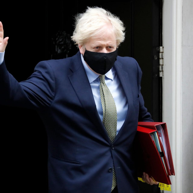Britain's Prime Minister Boris Johnson wearing a face mask or covering due to the COVID-19 pandemic, waves as he leaves number 10 Downing Street in central London on October 14, 2020, to take part in the Prime Minister Question (PMQs) session in the House of Commons. (Photo by Tolga AKMEN/AFP)