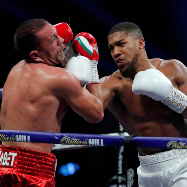 Britain's Anthony Joshua (R) lands a punch on Bulgaria's Kubrat Pulev (L) during their heavyweight world title boxing match at Wembley Arena in north west London on December 12, 2020. (Photo by ANDREW COULDRIDGE/POOL/AFP)