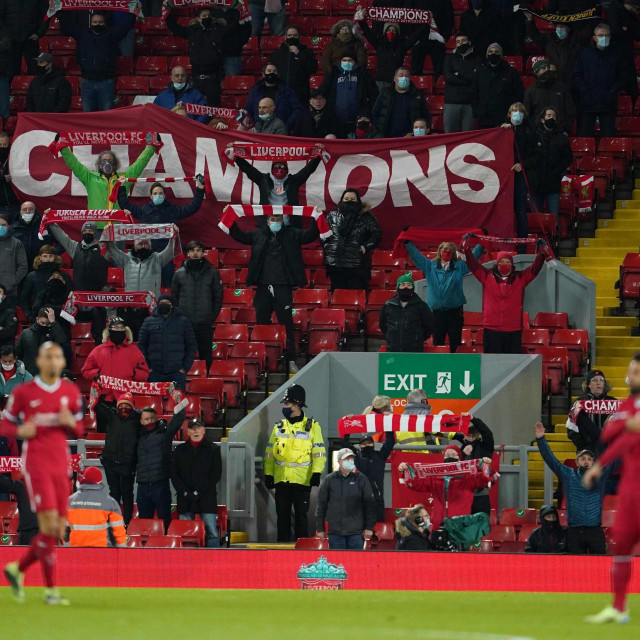 Liverpool fans, standing socially distanced due to the COVID-19 pandemic, watch during the English Premier League football match between Liverpool and Tottenham Hotspur at Anfield in Liverpool, north west England on December 16, 2020. (Photo by Jon Super/POOL/AFP)/RESTRICTED TO EDITORIAL USE. No use with unauthorized audio, video, data, fixture lists, club/league logos or ‘live‘ services. Online in-match use limited to 120 images. An additional 40 images may be used in extra time. No video emulation. Social media in-match use limited to 120 images. An additional 40 images may be used in extra time. No use in betting publications, games or single club/league/player publications./