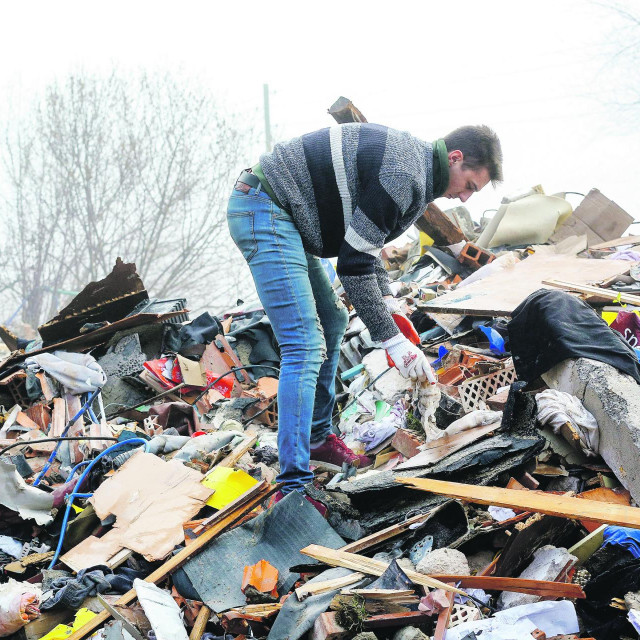 Ivan Tomić, u maskirnom prsluku i šeširu, s rodbinom koja je došla iz Slavonskog Broda pretražuje ostatke bratove kuće