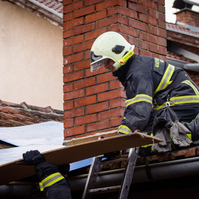 Vatrogasac radi na saniranju oštećenog krova