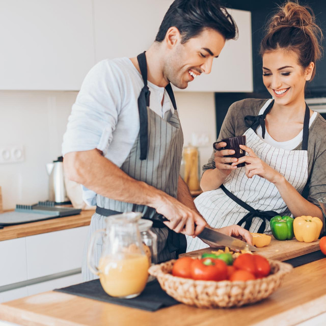 Lovely couple making salad in the kitchen.
