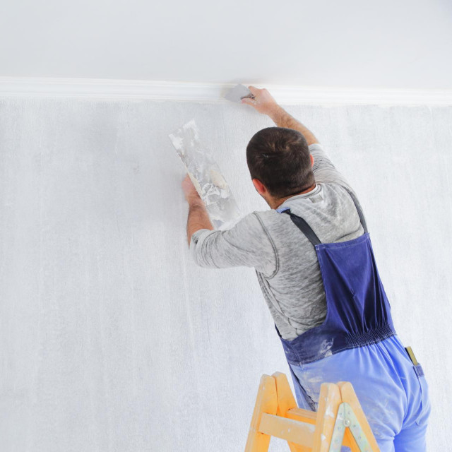 Men painting empty home interior
