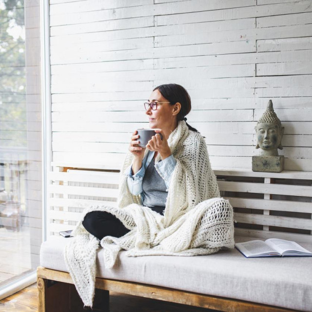 Woman sitting comfortable and looking through the window