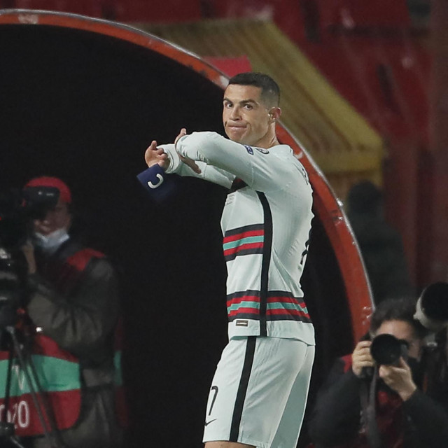 Portugal's forward Cristiano Ronaldo holds his captain armband moments before he threw it to the ground and left the pitch at the end of the FIFA World Cup Qatar 2022 qualification Group A football match between Serbia and Portugal at the Rajko Mitic Stadium, in Belgrade, on March 27, 2021. - Cristiano Ronaldo threw his captain's armband to the ground in anger after being controversially denied an injury-time winner as Portugal blew a two-goal lead against Serbia in World Cup qualifying. (Photo by pedja milosavljevic/AFP)