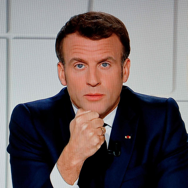 French President Emmanuel Macron is seen on a TV screen as he speaks during a televised address on the new Covid-19 restrictions from the Elysee Palace in Paris on March 31, 2021. (Photo by Ludovic MARIN/AFP)