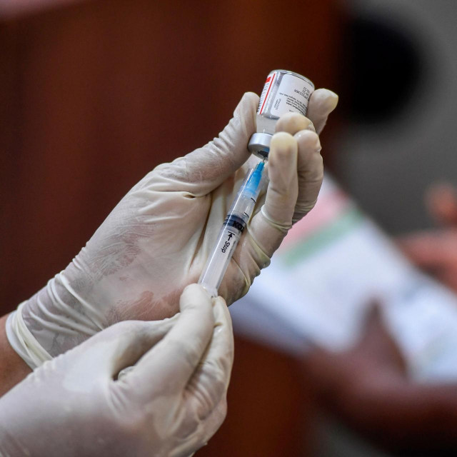 A health worker prepares a dose to inoculate a woman with the Covaxin Covid-19 coronavirus vaccine at a school-turned-vaccination centre in New Delhi on May 5, 2021. (Photo by Tauseef MUSTAFA/AFP)