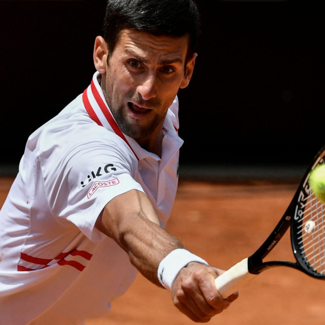 Serbia's Novak Djokovic returns a backhand to Greece's Stefanos Tsitsipas during their quarter final match of the Men's Italian Open at Foro Italico on May 15, 2021 in Rome, Italy. (Photo by Filippo MONTEFORTE/AFP)