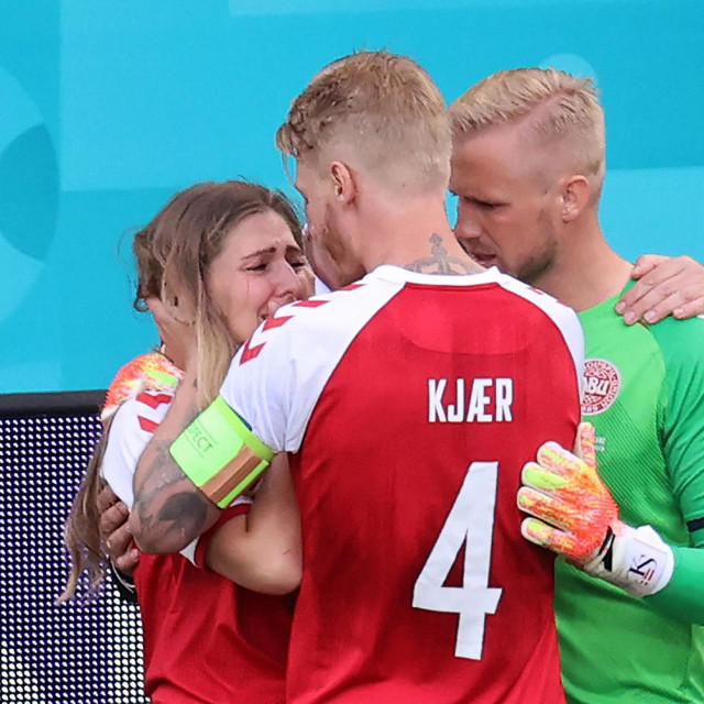 Kasper Schmeichel (desno) i kapetan Simon Kjaer (u sredini) tješe Eriksenovu partnericu Sabrinu Kvist Jensen