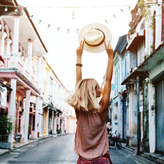 Boho girl walking on the city street. Travelling in Phuket Old Town in Thailand.