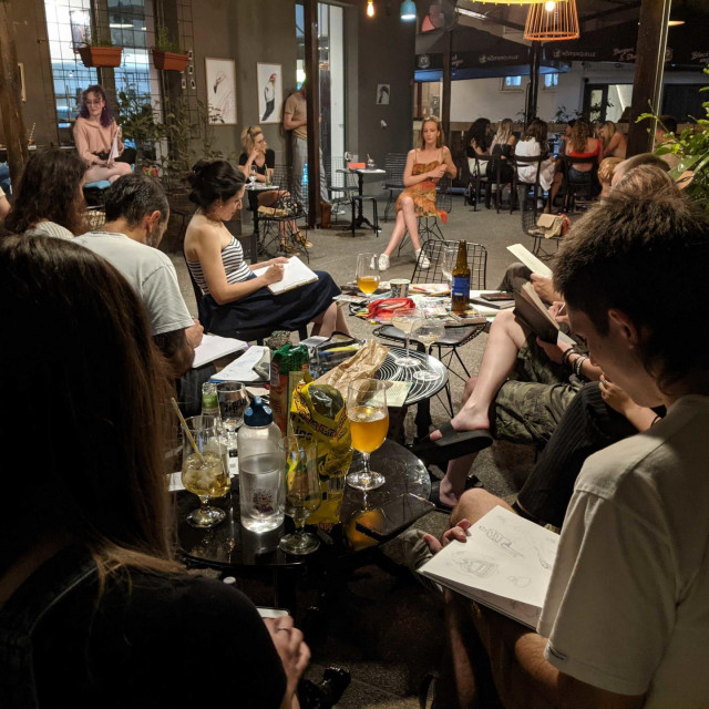 Drink &Draw večer u Varšavskoj u caffe baru Bustan u Varšavskoj koju obožavaju stranci. Jedan gost pozira, drugi piju i crtaju ga