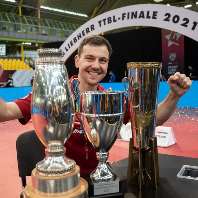 06 June 2021, North Rhine-Westphalia, Dortmund: Finals 2021 - Table Tennis Bundesliga Final Borussia Düsseldorf - 1. FC Saarbrücken TT in the Helmut Körnig Halle: Düsseldorf's Timo Boll cheers after the final with the trophies for the Cup Winner, the Champions League and the German Team Champion. Photo: Bernd Thissen/dpa (Photo by BERND THISSEN/DPA/dpa Picture-Alliance via AFP)