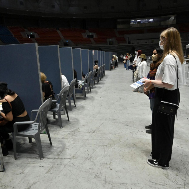Visitors wait to test for the Covid-19 coronavirus with rapid self-test kit before entering a music festival at Olympic park in Seoul on June 26, 2021. (Photo by Jung Yeon-je/AFP)