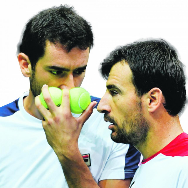 Croatia's Marin Cilic (L) and Ivan Dodig (R) discuss tactics before serving the ball to France's Pierre-Hugues Herbert and Nicolas Mahut during the Davis Cup World Group semifinal doubles match between Croatia and France at ”Kresimir Cosic” hall in Zadar, on September 17, 2016. (Photo by ANDREJ ISAKOVIC/AFP)