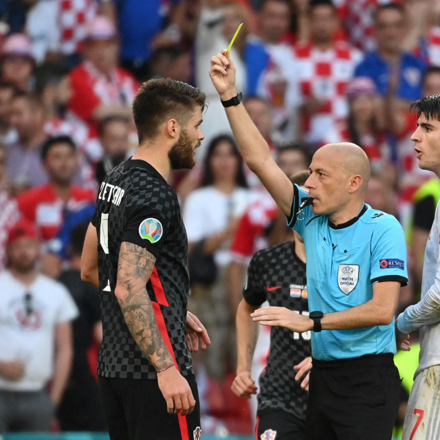 Turkish referee Cuneyt Cakir presents a yellow card to Croatia's defender Duje Caleta-Car (L) during the UEFA EURO 2020 round of 16 football match between Croatia and Spain at the Parken Stadium in Copenhagen on June 28, 2021. (Photo by Jonathan NACKSTRAND/POOL/AFP)