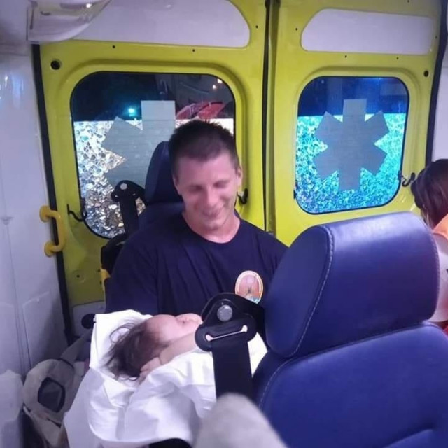 Riječki vatrogasac drži bebu u kolima Hitne pomoći