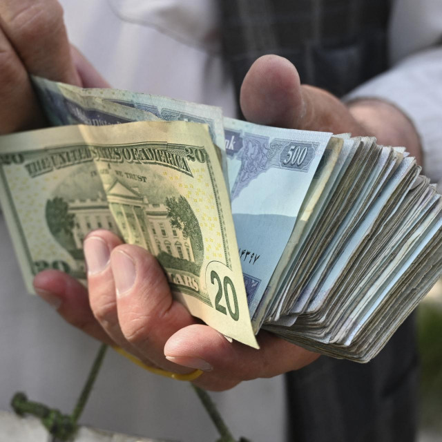 Mjenjač broji afganistanske novčanice i američke dolare