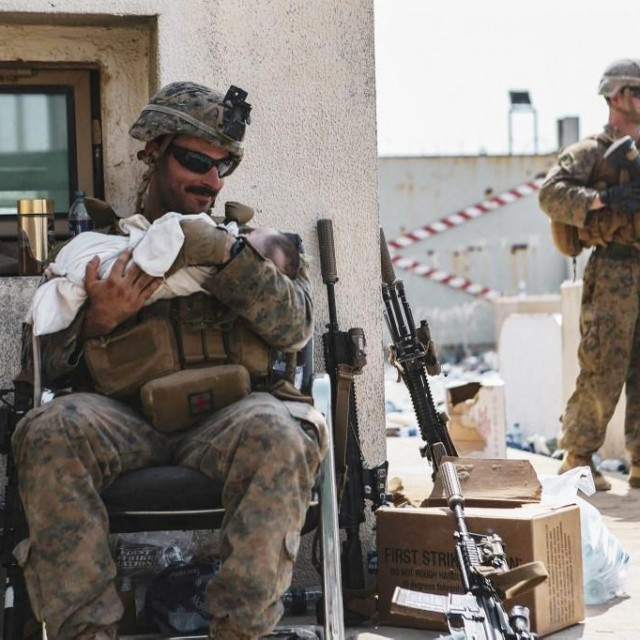 Američki marinac u naručju drži malenu bebu