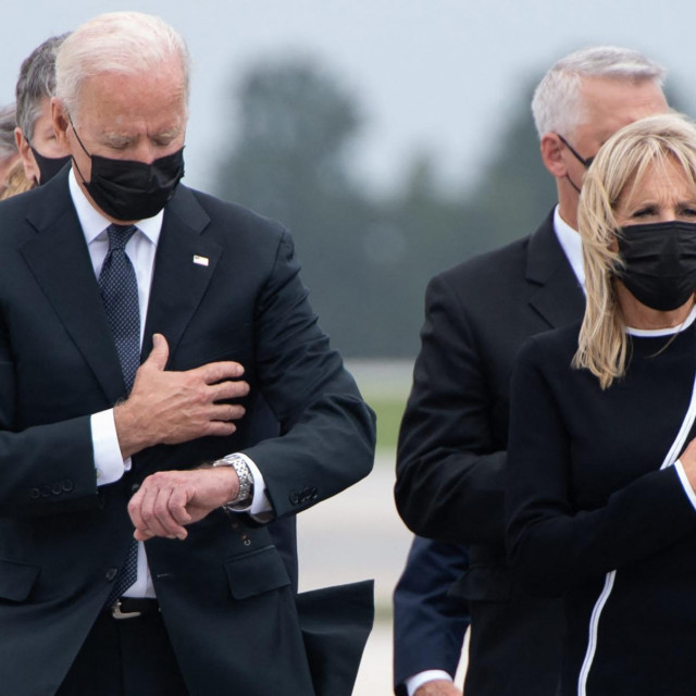 Američki predsjednik Joe Biden gleda dolje zajedno s prvom damom Jill Biden dok prisustvuju dostojanstvenom ispraćaju posmrtnih ostataka poginulih pripadnika službe