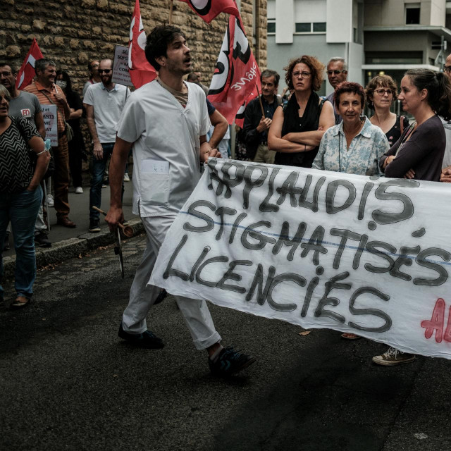 Članovi medicinskog osoblja drže transparent s natpisom ”
Jučer pljesak, danas stigmatiziran”