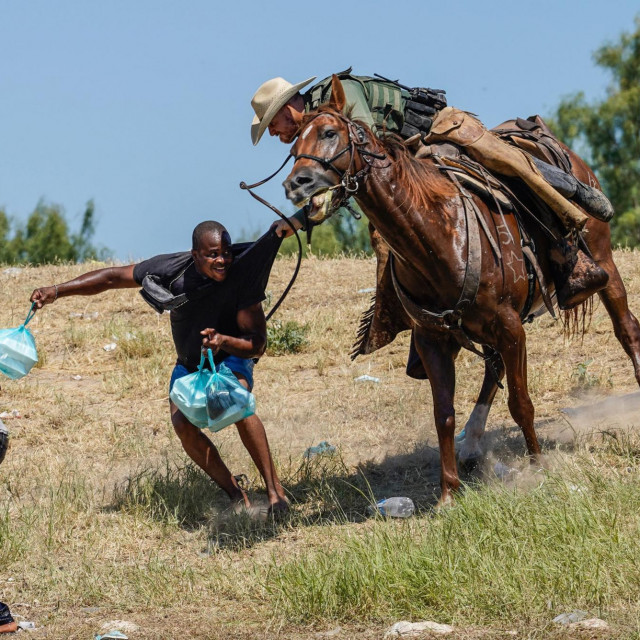 Agent granične ophodnje Sjedinjenih Država na konju pokušava spriječiti migranta iz Haitija da uđe u kamp na obali Rio Grande 