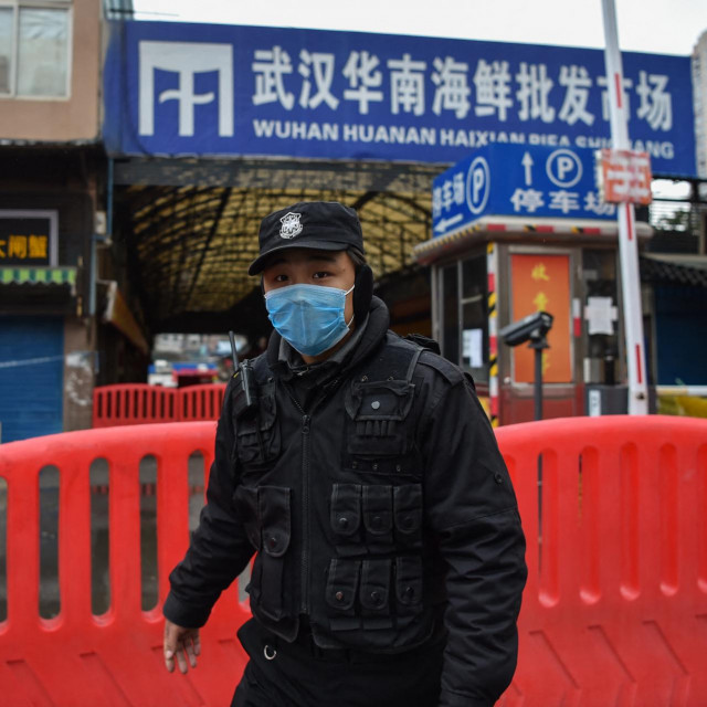 Policajac stoji pred tržnicom u Wuhanu